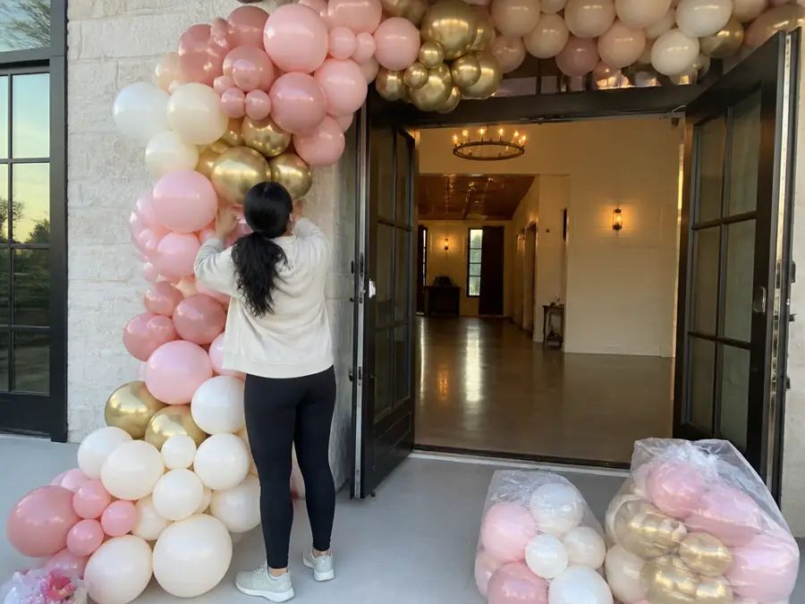 Installing a balloon garland at an event hall